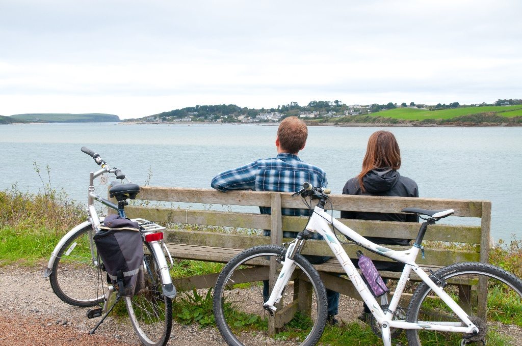 two people on a bench with bikes