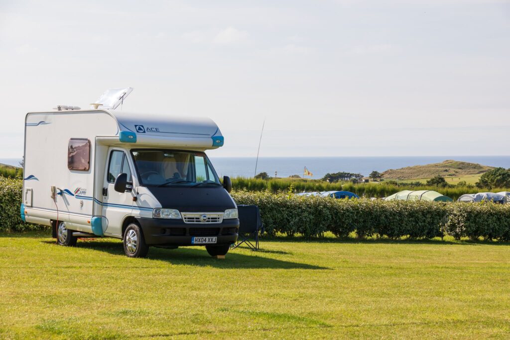 Motorhome on a grass pitch at Trevornick touring and camping site with coastal views, Cornwall